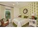 Comfortable bedroom features a ceiling fan and a window overlooking outdoor landscaping at 26687 Raphis Royale Blvd, Englewood, FL 34223