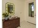 Entryway with elegant dresser, stylish mirror, and a glass-paneled door offering views of the lush landscape at 26687 Raphis Royale Blvd, Englewood, FL 34223
