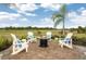 Relaxing outdoor fire pit area with Adirondack chairs, perfect for enjoying serene views and cool evenings at 26687 Raphis Royale Blvd, Englewood, FL 34223
