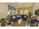 Living room features a comfortable, oversized sectional, neutral walls, and an adjacent office space at 26687 Raphis Royale Blvd, Englewood, FL 34223