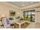 Bright living room with a white sofa, decorative pillows, and large windows at 26687 Raphis Royale Blvd, Englewood, FL 34223