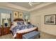 Bright bedroom features tray ceiling, a ceiling fan, plantation shutters, and an ensuite bathroom at 26687 Raphis Royale Blvd, Englewood, FL 34223