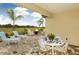 Covered outdoor patio featuring a paver floor and elegant dining area with views of the green space beyond at 26687 Raphis Royale Blvd, Englewood, FL 34223