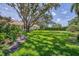 A view of the vast backyard with mature landscaping, grass and trees at 2914 Dick Wilson Dr, Sarasota, FL 34240