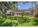 View of a large backyard with a screened in pool area and mature trees at 2914 Dick Wilson Dr, Sarasota, FL 34240