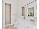 Modern bathroom features a glass shower, white vanity with marble countertop, and large mirror at 2914 Dick Wilson Dr, Sarasota, FL 34240