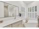 Modern bathroom featuring a large mirror, soaking tub, and windows with plantation shutters at 2914 Dick Wilson Dr, Sarasota, FL 34240
