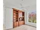 Well-lit room with hardwood floors, a ceiling fan, a window, and attractive wood built-in shelving at 2914 Dick Wilson Dr, Sarasota, FL 34240