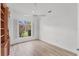 Well-lit bedroom with hardwood floors, a ceiling fan, and a window providing a view of outdoor foliage at 2914 Dick Wilson Dr, Sarasota, FL 34240