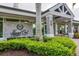 Exterior of Laurel Oak Country Club clubhouse with stone accents, lush landscaping and manicured hedges at 2914 Dick Wilson Dr, Sarasota, FL 34240