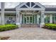 Welcoming entrance to the clubhouse with brick pavers, manicured landscaping, and stone facade at 2914 Dick Wilson Dr, Sarasota, FL 34240
