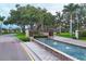 Picturesque community entrance with water feature, lush landscaping, and stately trees lining the driveway at 2914 Dick Wilson Dr, Sarasota, FL 34240