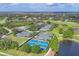 A wide view showing manicured tennis and pickleball courts as well as a pool and golf course at 2914 Dick Wilson Dr, Sarasota, FL 34240