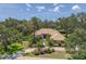 Stunning front exterior with lush landscaping, mature trees, and a circular driveway leading up to the entrance at 2914 Dick Wilson Dr, Sarasota, FL 34240