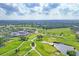 Expansive aerial shot of the golf course featuring undulating greens, mature trees, water features, and the clubhouse at 2914 Dick Wilson Dr, Sarasota, FL 34240