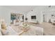 Bright and spacious living room featuring elegant white furniture and sliding glass doors to the pool at 2914 Dick Wilson Dr, Sarasota, FL 34240