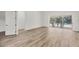 Bright, open living area with wood-look flooring and sliding glass doors leading to the pool area at 2914 Dick Wilson Dr, Sarasota, FL 34240