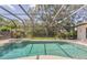 An above ground view of the screened in lanai with a swimming pool, jacuzzi, and beautiful greenery at 2914 Dick Wilson Dr, Sarasota, FL 34240