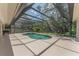 An aerial view of the swimming pool in the screened lanai with surrounding trees and blue skies at 2914 Dick Wilson Dr, Sarasota, FL 34240