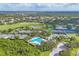 Aerial view showcasing tennis courts and pool surrounded by verdant trees and manicured landscaping at 2914 Dick Wilson Dr, Sarasota, FL 34240