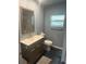Modern bathroom features a decorative window, wood-framed mirror and floating vanity at 3060 Courtland St, Sarasota, FL 34237