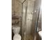 Bathroom with tiled shower, glass door, shelving, and modern fixtures at 3060 Courtland St, Sarasota, FL 34237