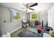 Bedroom featuring a ceiling fan, two windows for natural light, and neutral wall colors at 3468 Roslyn Rd, Venice, FL 34293