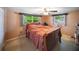 Cozy bedroom with an orange bedspread, a window with natural light, and a dresser at 3468 Roslyn Rd, Venice, FL 34293