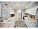 Bright kitchen with white cabinets, double sink, tile backsplash, and modern appliances at 3468 Roslyn Rd, Venice, FL 34293