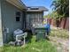 Home exterior featuring utilities and solar panels, surrounded by unkempt foliage and overgrown grass at 3646 Lakewood Dr, Sarasota, FL 34232