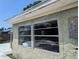 Exterior wall showing broken windows, indicating damage and neglect to the property at 3646 Lakewood Dr, Sarasota, FL 34232
