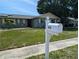 Charming one-story home with a green lawn and neatly trimmed shrubs, complemented by a white mailbox at 3646 Lakewood Dr, Sarasota, FL 34232