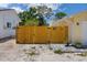 Fenced backyard entrance with a wooden gate and well-manicured plants at 4076 Vana Dr, Sarasota, FL 34241
