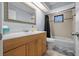 Bathroom featuring a wooden vanity, a large mirror, and a tiled shower/bath at 4076 Vana Dr, Sarasota, FL 34241