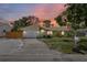 Charming single-story home with an attached garage and well-maintained front lawn at sunset at 4076 Vana Dr, Sarasota, FL 34241