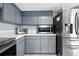 Corner kitchen with stainless steel refrigerator, microwave, toaster oven, and gray cabinets at 4076 Vana Dr, Sarasota, FL 34241