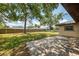 Paver patio flows onto grassy backyard, shaded by mature trees and enclosed with wood fence at 4155 Center Gate Blvd, Sarasota, FL 34233