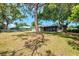 Large, grassy backyard features mature trees, a privacy fence, and a screened patio at 4155 Center Gate Blvd, Sarasota, FL 34233