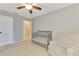 Neutral Bedroom featuring a gray crib, an accent chair, and a ceiling fan at 4155 Center Gate Blvd, Sarasota, FL 34233
