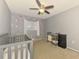 Bedroom with soft gray walls with pink polka dots, crib, and neutral colored furnishings at 4155 Center Gate Blvd, Sarasota, FL 34233