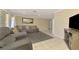 Open-concept living area with tile flooring, a sectional sofa, and a large television at 4155 Center Gate Blvd, Sarasota, FL 34233