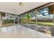 Screened-in patio featuring white tile flooring and views of the fenced backyard and mature trees at 4155 Center Gate Blvd, Sarasota, FL 34233