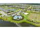 Community aerial view featuring a pool, sport courts, playground, manicured lawn, and pristine lake at 4430 Pond Brook Ct, Bradenton, FL 34211