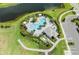 Aerial view showcases a sparkling pool with palm trees, lounge chairs, cabanas, and manicured landscaping at 4430 Pond Brook Ct, Bradenton, FL 34211
