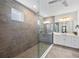 Modern bathroom with gray tiled walk-in shower, white double vanity, and a bright, airy feel at 4430 Pond Brook Ct, Bradenton, FL 34211