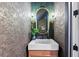 Stylish powder room featuring a modern vanity, a unique mirror, and designer lighting at 4430 Pond Brook Ct, Bradenton, FL 34211