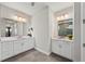 Bathroom with double sinks, large mirrors, modern lighting, and tiled floors at 4430 Pond Brook Ct, Bradenton, FL 34211
