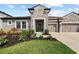 Charming home exterior featuring stone accents, manicured lawn, and a two-car garage at 4430 Pond Brook Ct, Bradenton, FL 34211
