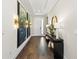 Inviting hallway with hardwood floors, a console table, stylish decor, and leading to the entrance at 4430 Pond Brook Ct, Bradenton, FL 34211
