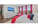 Main bedroom features a dresser with a television and large windows showcasing a beautiful view with red curtains at 4430 Pond Brook Ct, Bradenton, FL 34211